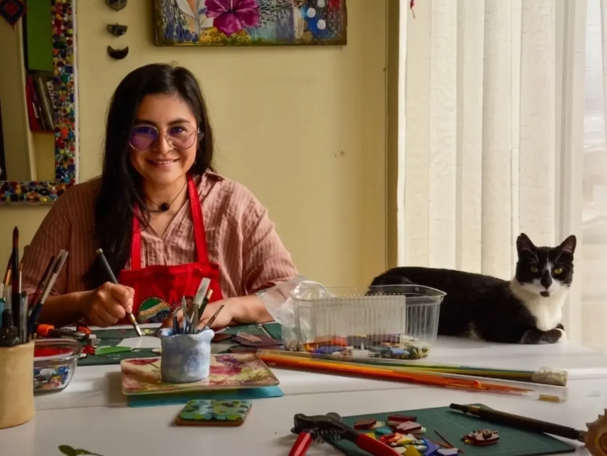 Adriana Moya en su mesa de trabajo, acompañada de su gato